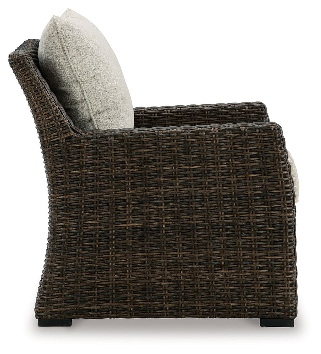 Brown woven lounge chair with beige back pillow, side view