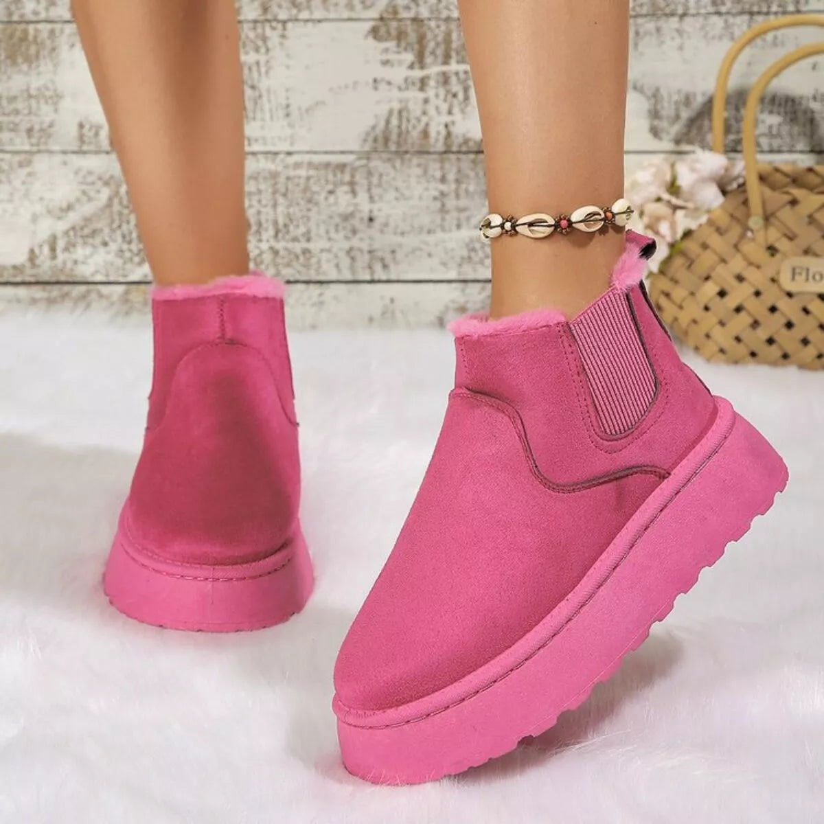 Hot pink suede platform ankle boots with round toe, side elastic gore, and faux fur cuff