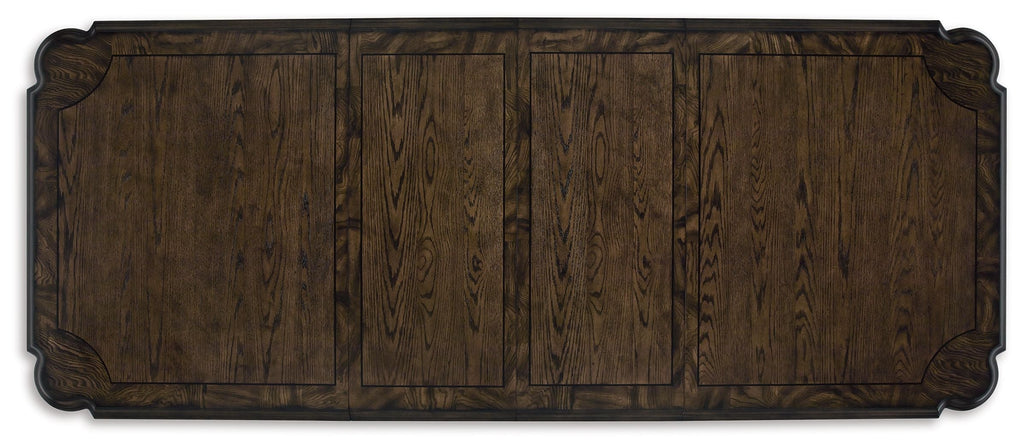 Dark brown extension table top with carved border and visible wood plank grain