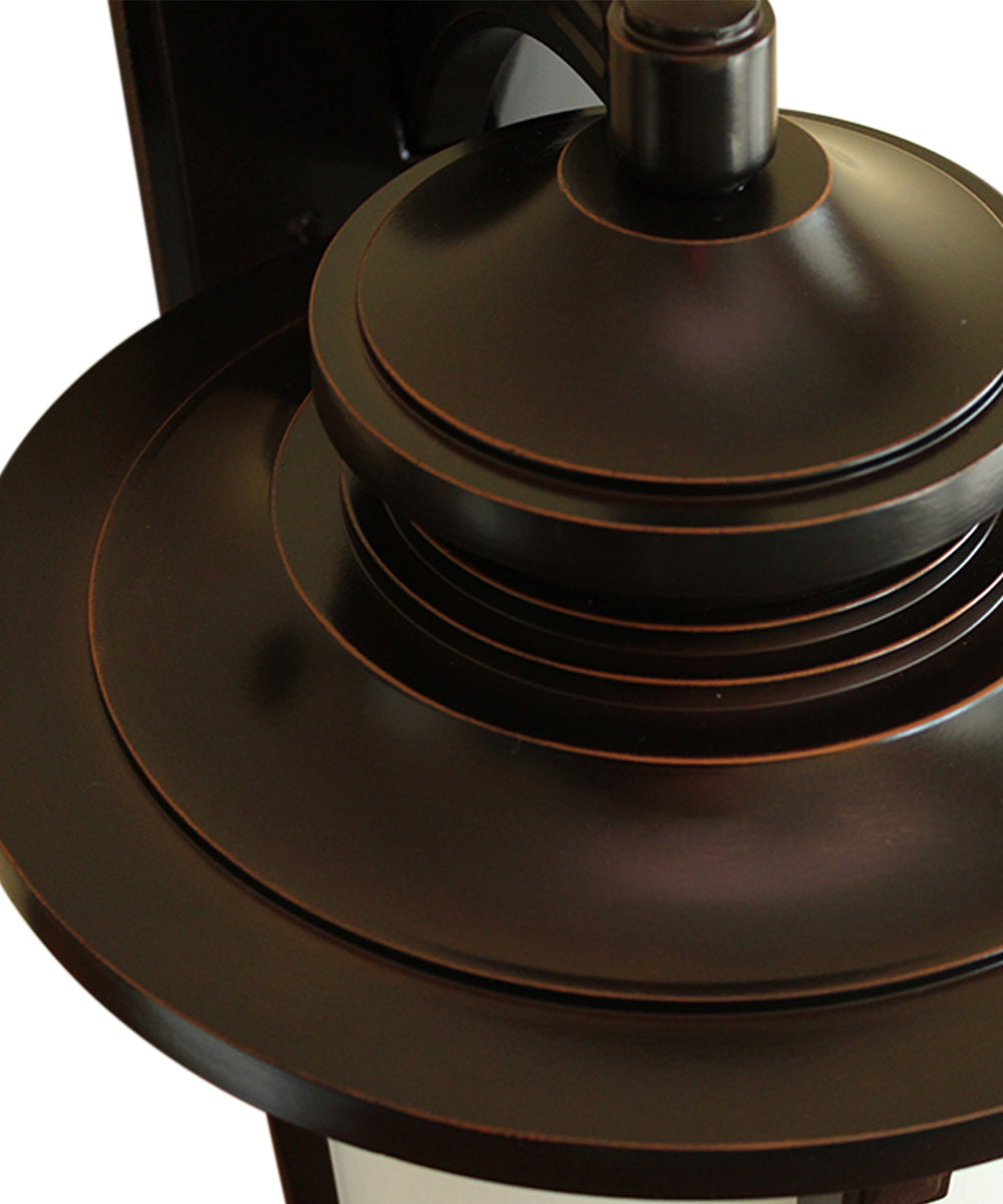 Bronze outdoor lantern top with stacked trim and mounting cap over frosted glass