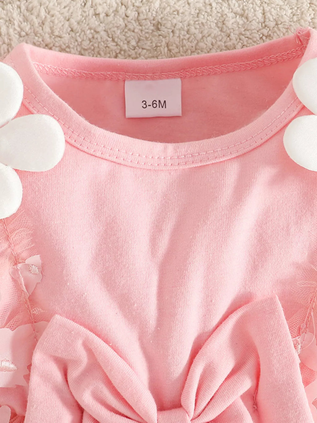 Pink short-sleeve dress with rounded neckline, bow detail, and 3-6M size tag