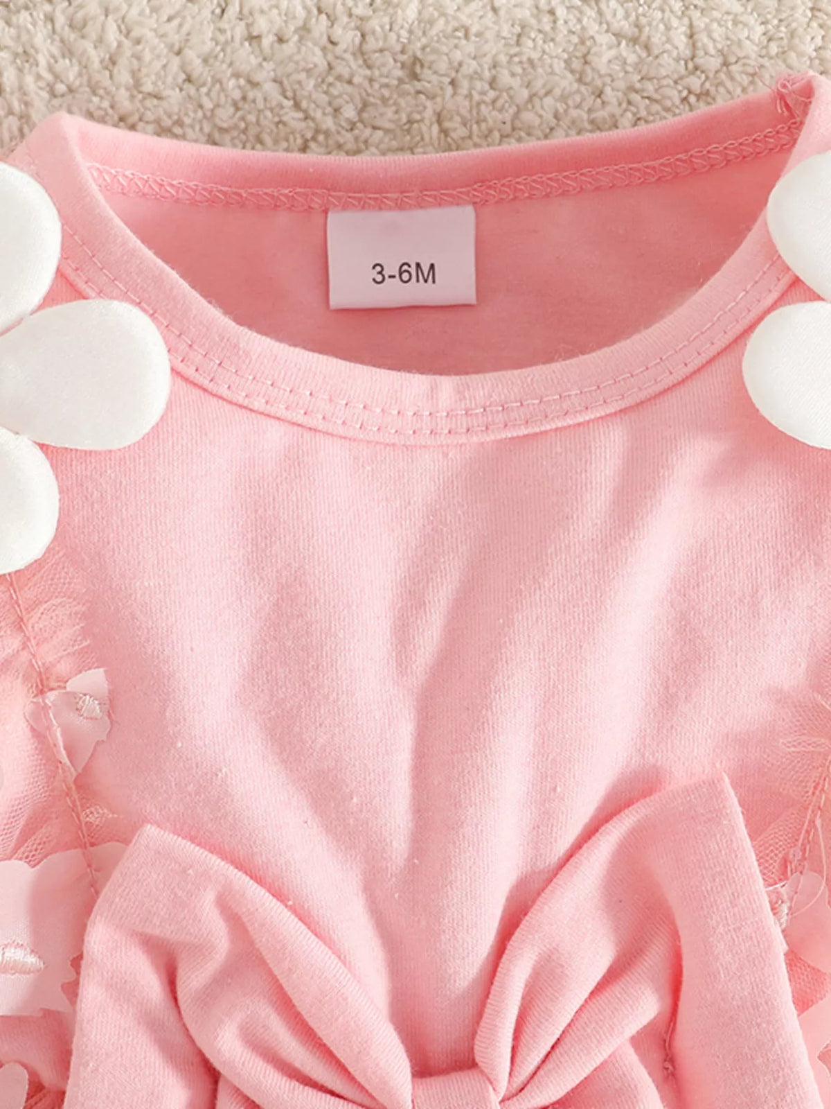 Pink short-sleeve dress with rounded neckline, bow detail, and 3-6M size tag