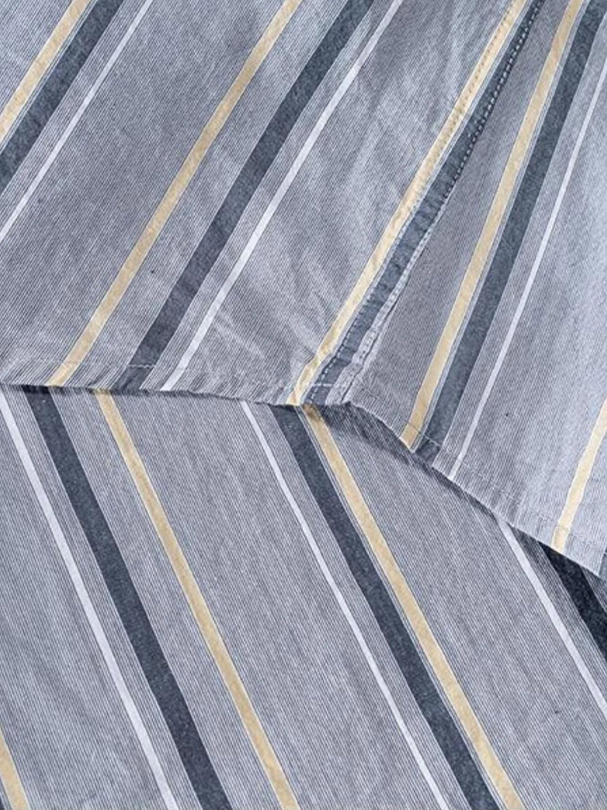Close-up of light gray striped shirt fabric and side seam detail.