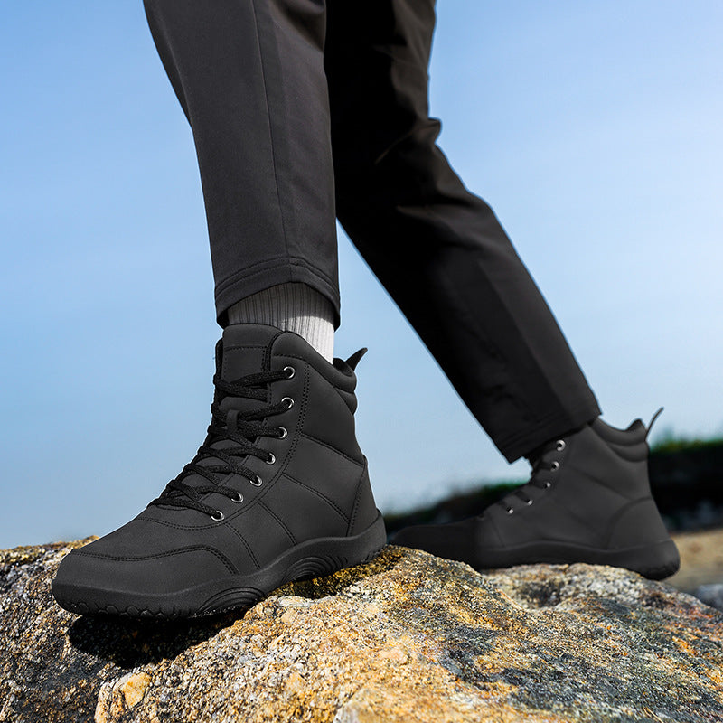 Men's black high-top hiking shoes with lace-up closure on rocky surface
