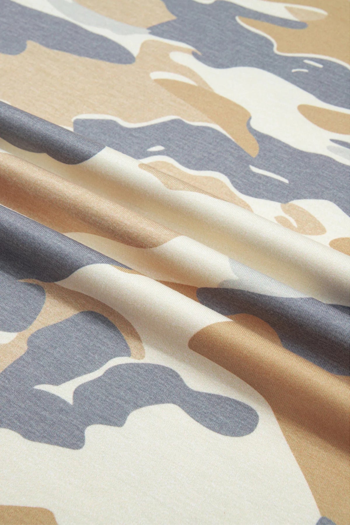 Camo print fabric close-up in beige, tan, gray, and blue