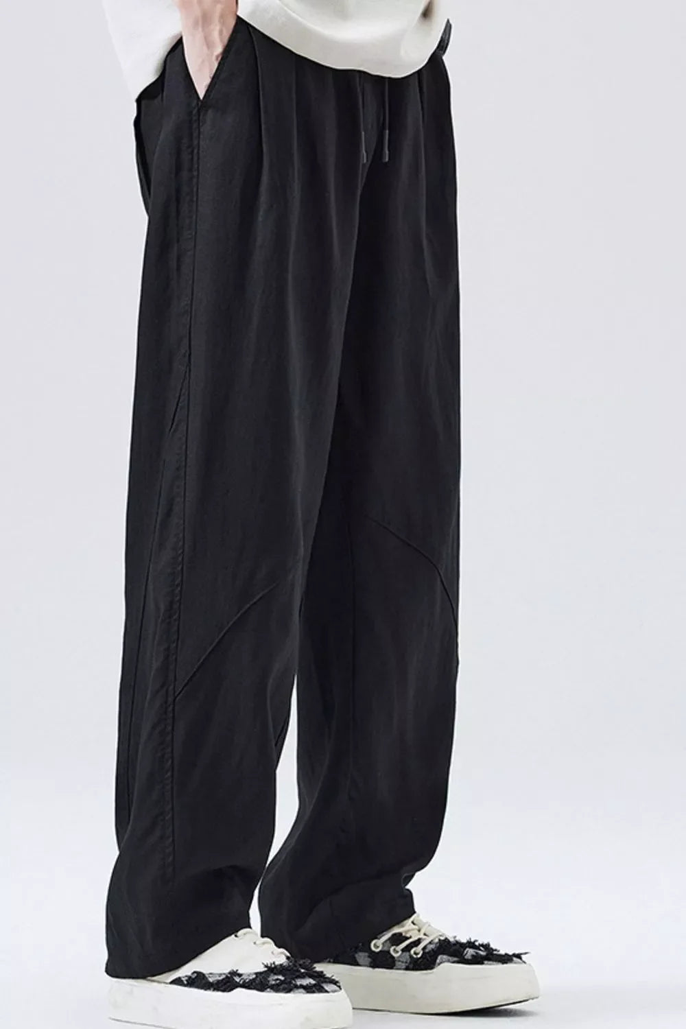 Black loose-fit drawstring pants with relaxed straight legs and diagonal side seams