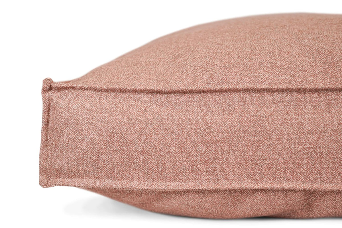 Dusty pink rectangular pet bed cushion with raised edge and tan label