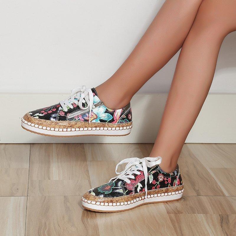 Floral lace-up women’s sneaker pair, black upper with multicolor floral print and tan sole