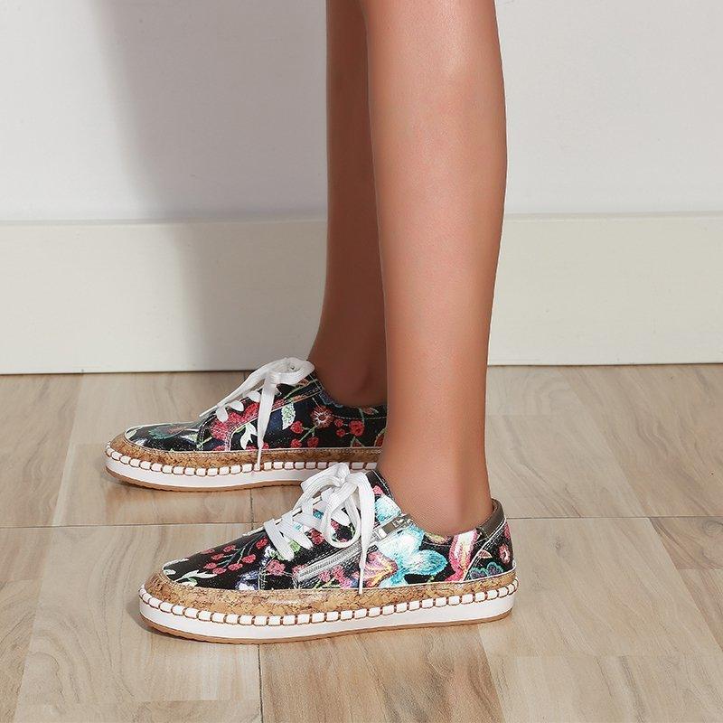 Women’s floral lace-up sneakers with dark patterned upper and brown textured sole