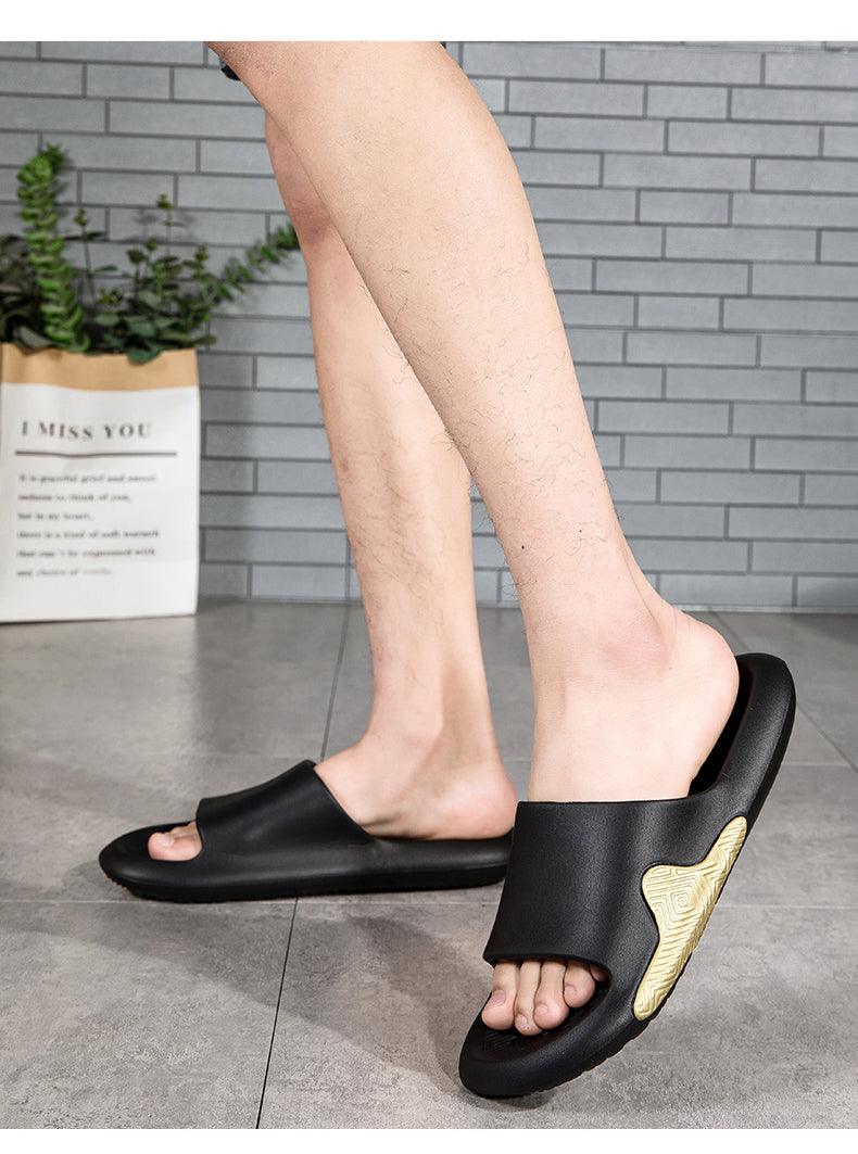 Black EVA slide sandals worn, open toe with gold side accent and textured outsole