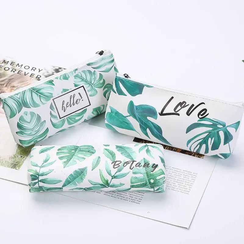 Small zip pencil pouch with green tropical leaf print and script-style “Love” graphic