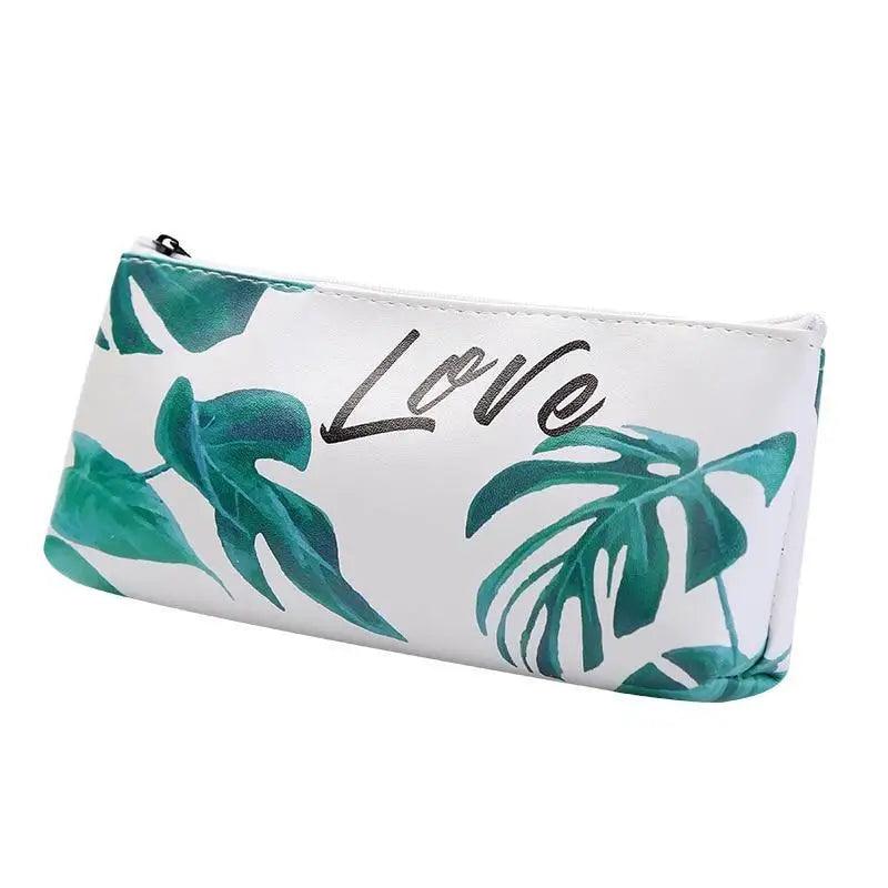 White pencil pouch with green tropical leaves and “Love” script graphic