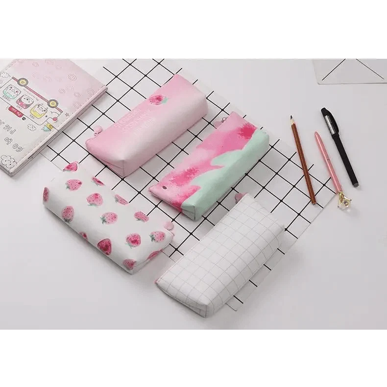 Three pastel printed pencil case pouches—pink, mint, and white with zip closure