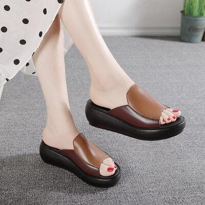 Brown leather slip-on platform wedge sandals with open toe and red nail polish