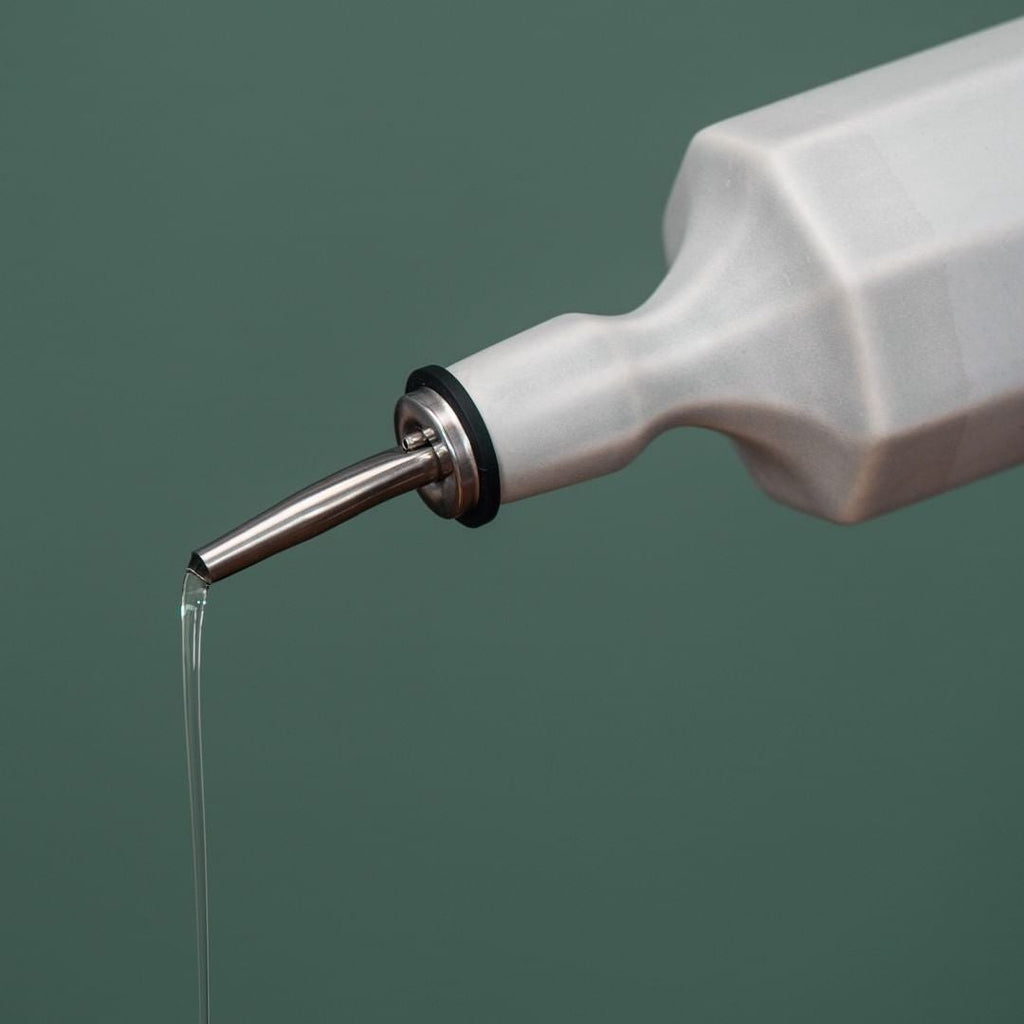 Silk white porcelain olive oil dispenser with metal spout dispensing oil