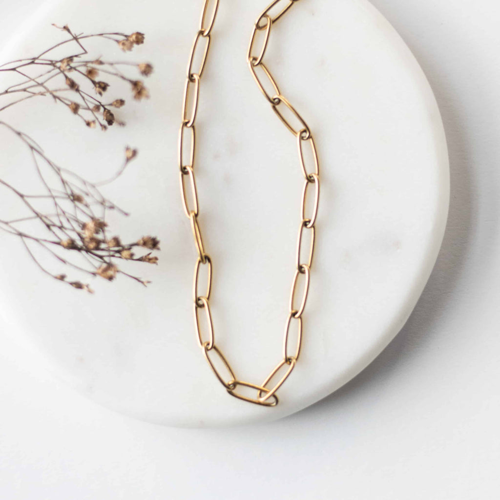 Gold-tone oval-link chain necklace with small clasp and charm detail