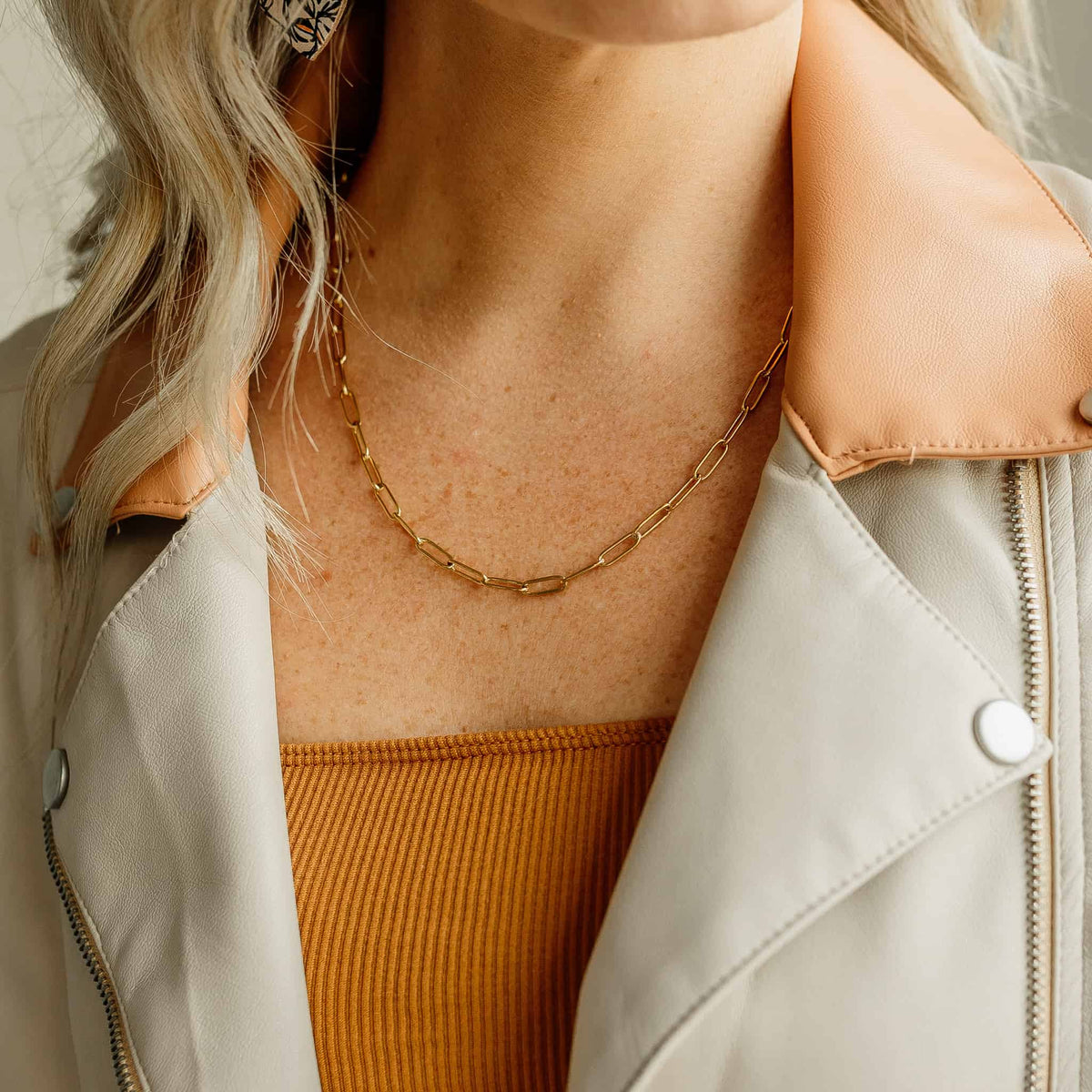 Gold-tone oval-link chain necklace worn at the neckline