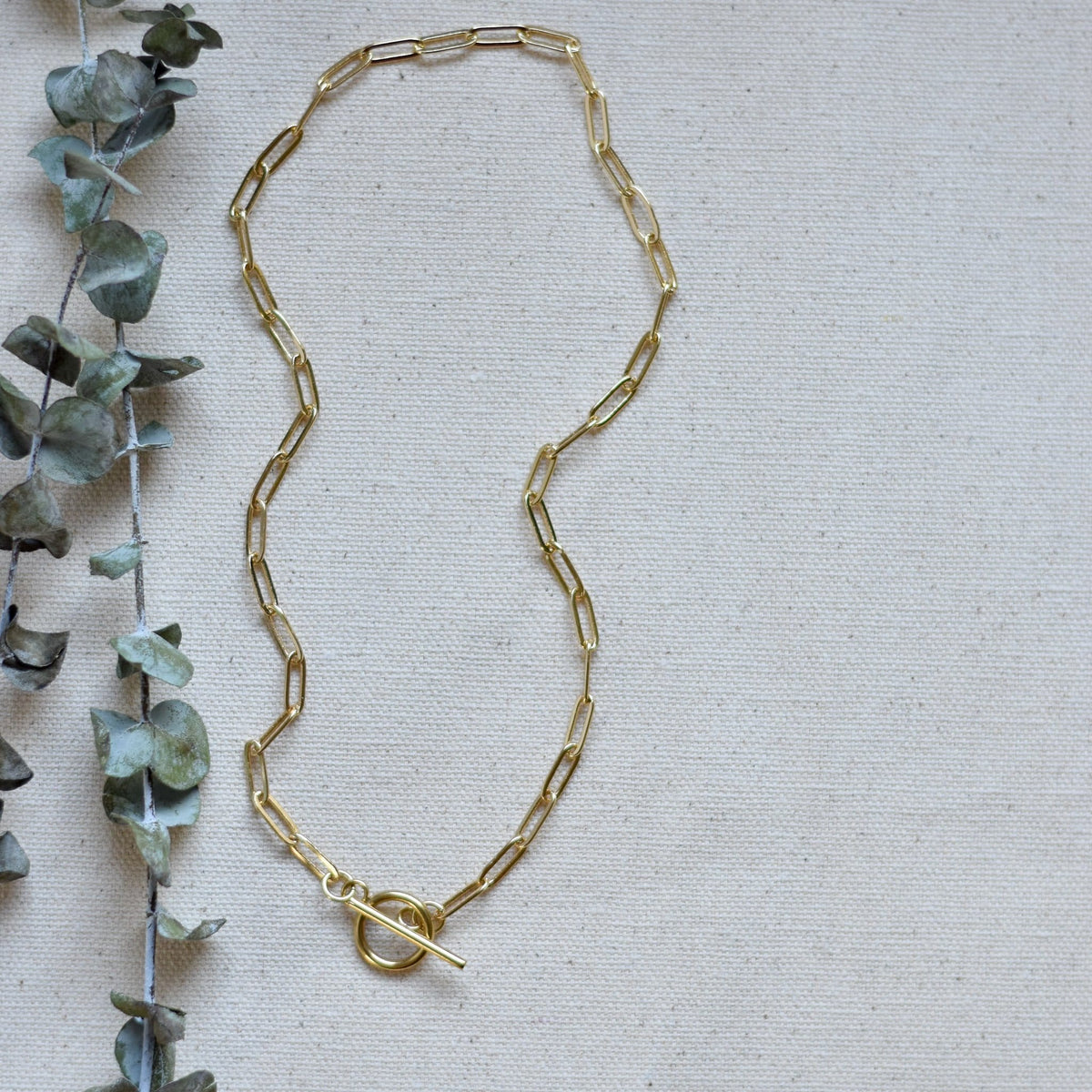 Gold-tone oval-link necklace with clasp detail at the center