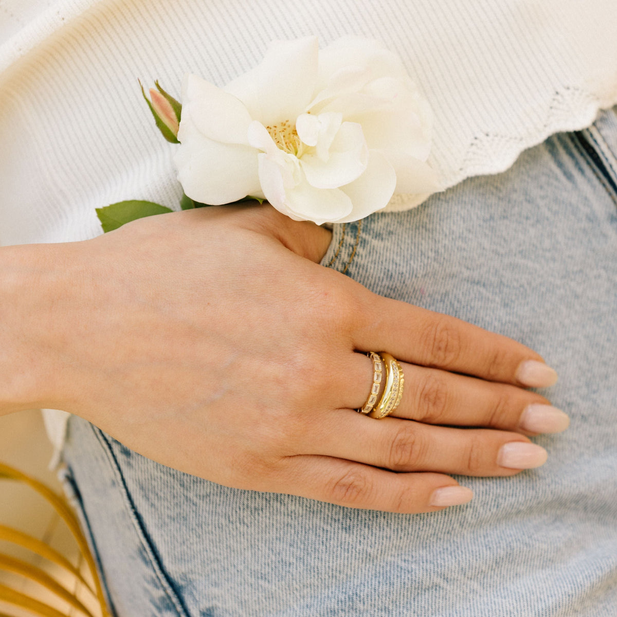 Gold-tone eternity band ring with rectangular clear stones on finger