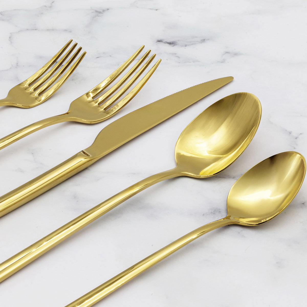 Gold mirror-finish flatware set on marble: forks, knives, and spoons