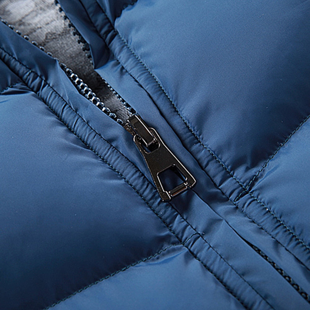 Blue sleeveless puffer vest close-up of front zipper and quilted panels