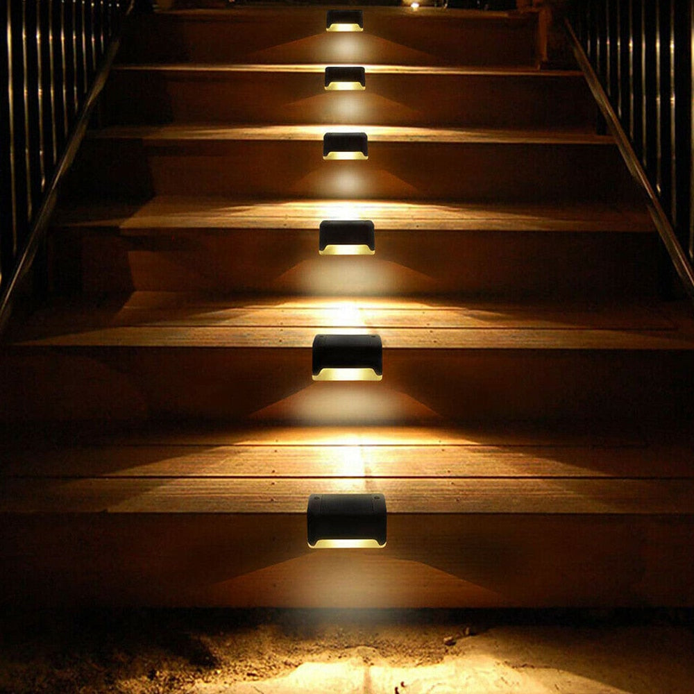 Black solar step lights illuminating outdoor stairs with warm LED