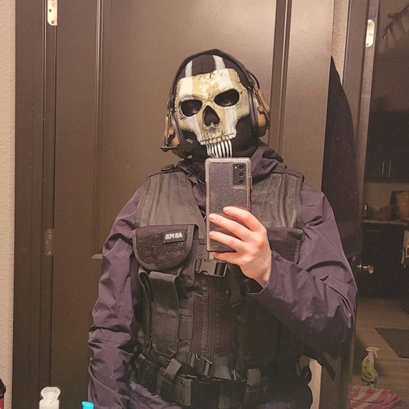 Person wearing black tactical skull face mask with painted skull and breathing openings