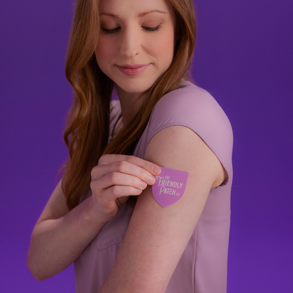 Purple vitamin patch applied to upper arm on a woman