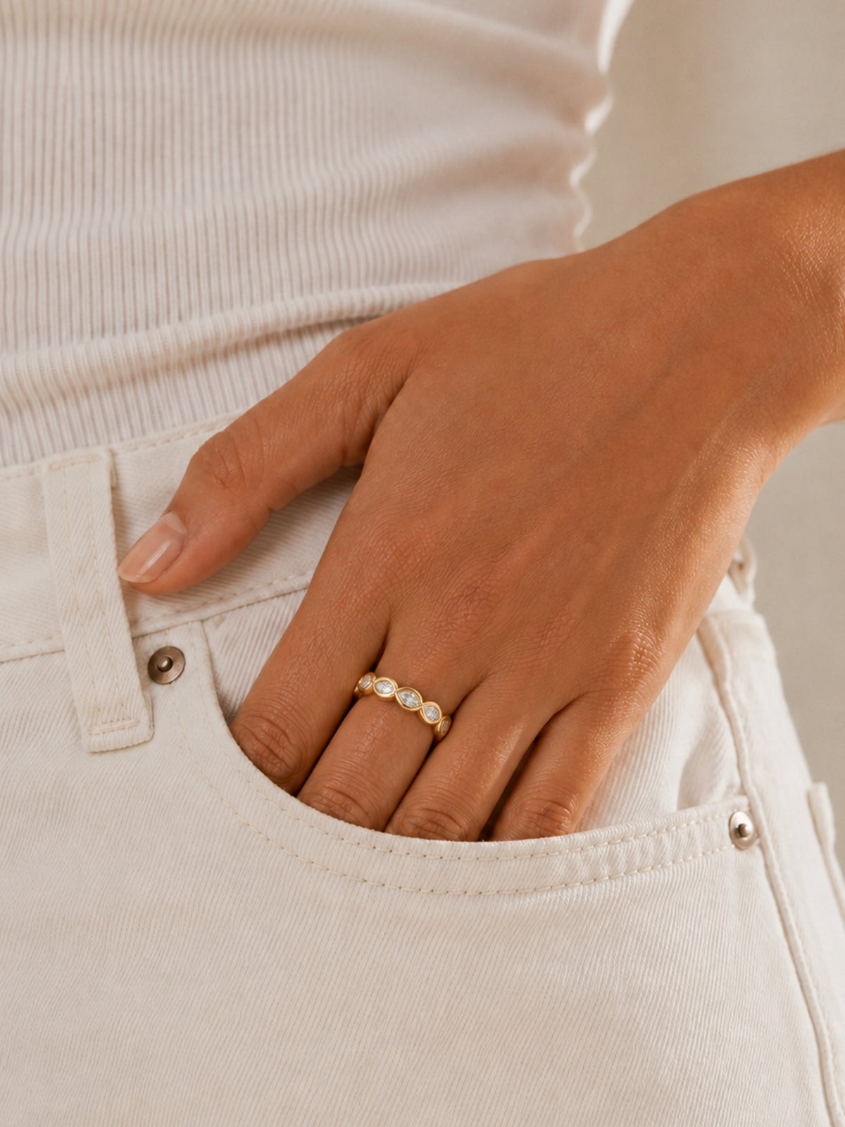 Gold gemstone ring with marquise-inspired settings worn on hand