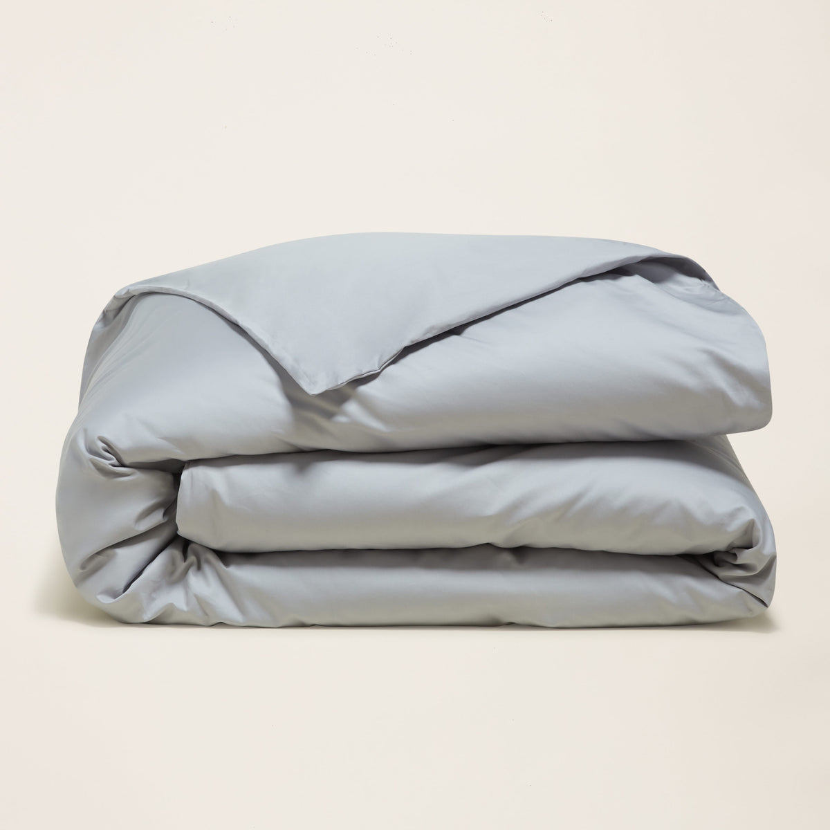 Light blue sateen duvet cover, folded in three layers with satin sheen.