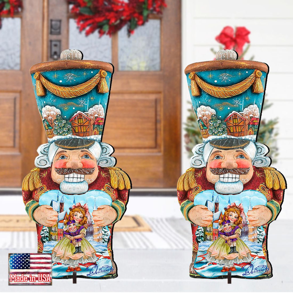 Painted blue nutcracker lawn decoration with white beard, holding doll, gold hat top