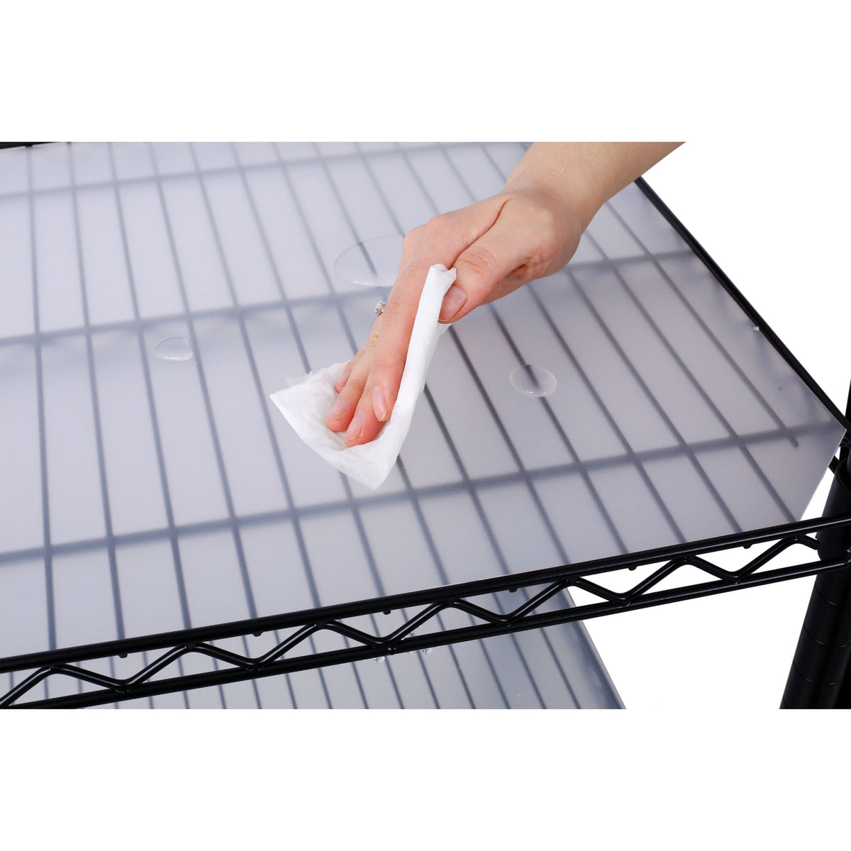 Black metal wire shelf with gray liner, wiped clean with a white cloth