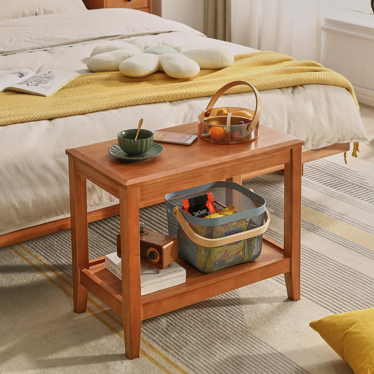 Wood side table beside a bed, with an open lower storage shelf