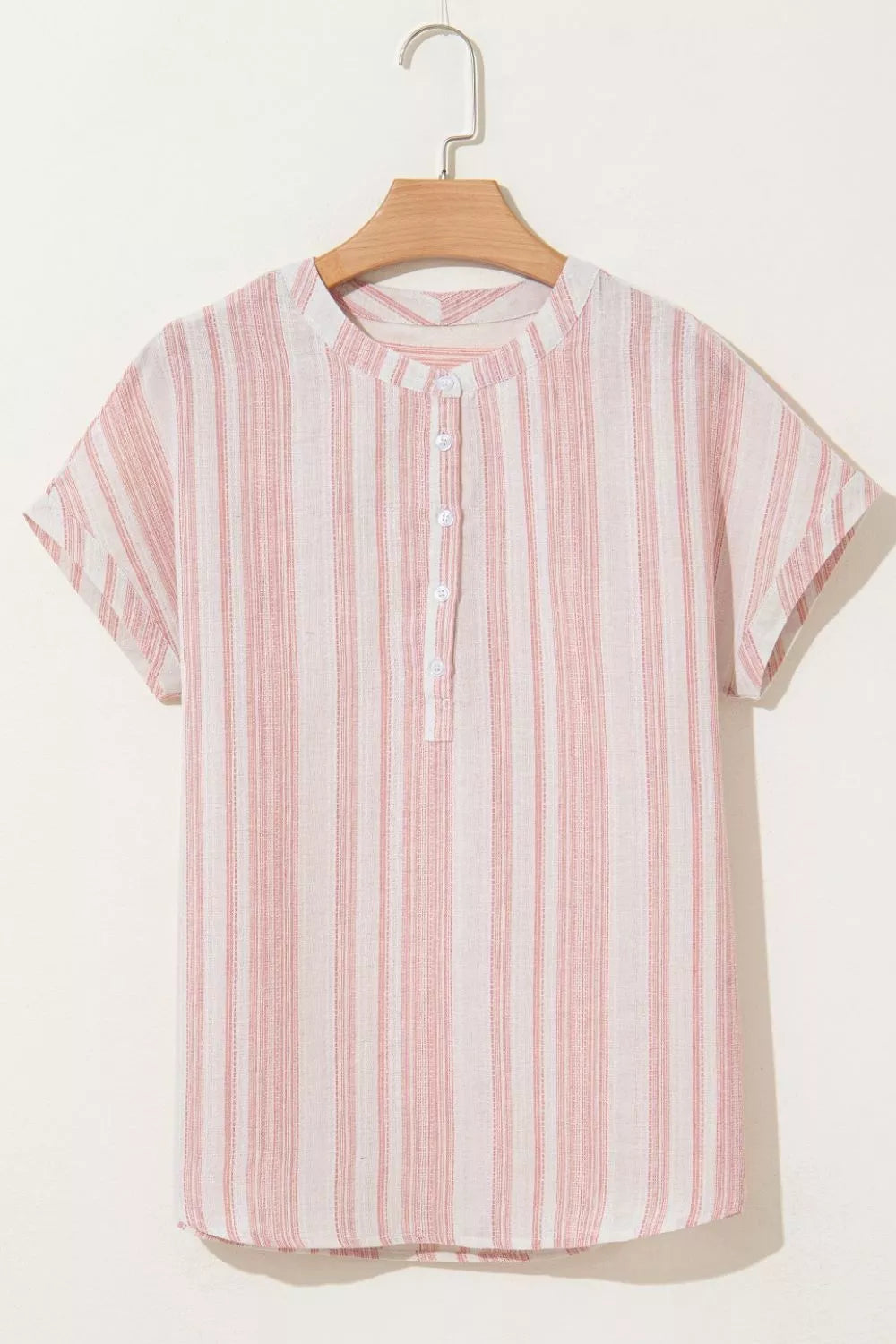 Dusty pink striped short-sleeve blouse on hanger, front with button detail