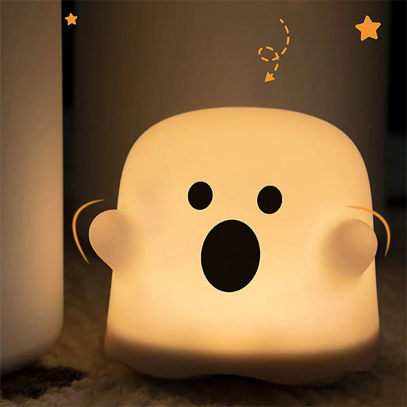 Warm glowing silicone ghost night light with round head and cartoon face markings.