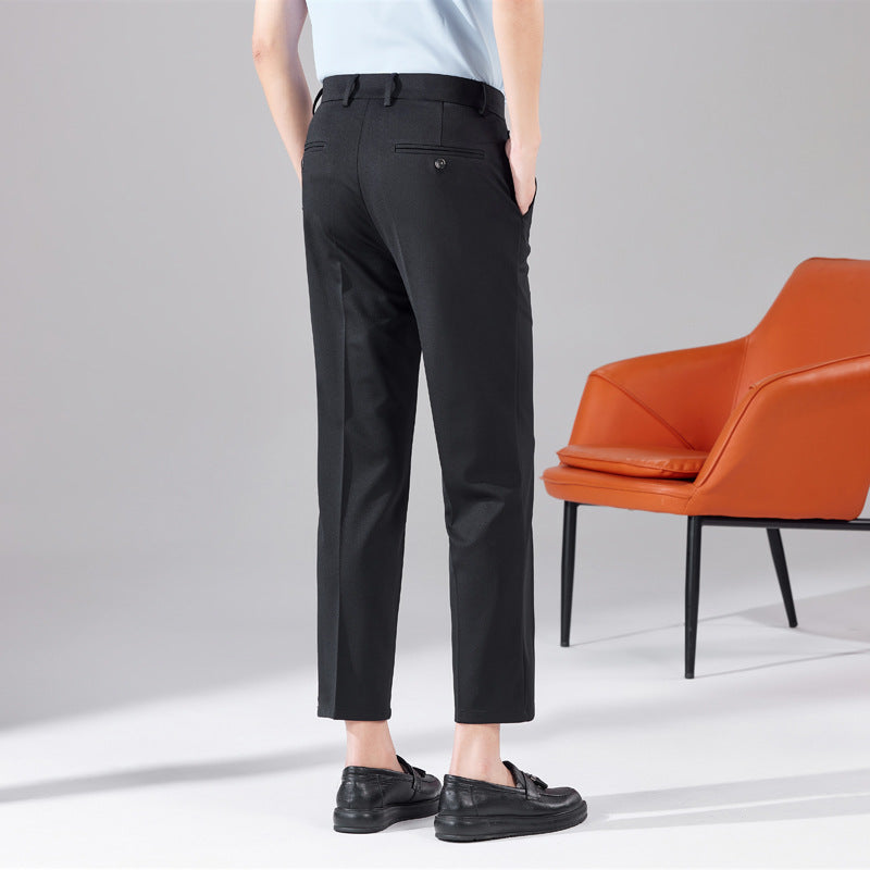 Black dress trousers with belt loops, front crease, and ankle-length tapered fit
