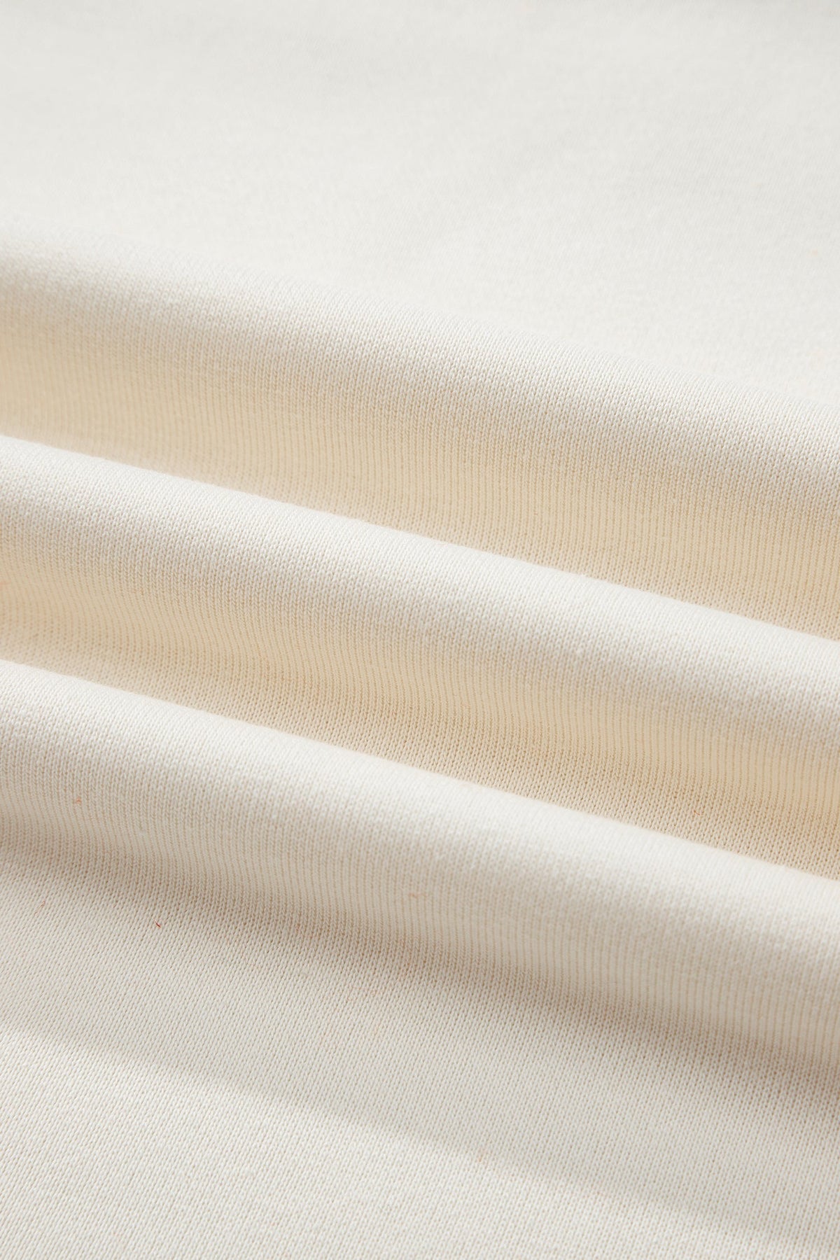 Cream knit sweatshirt fabric close-up with subtle ribbed texture