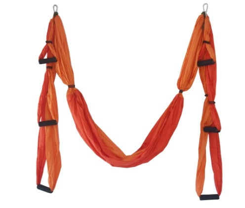 Orange aerial yoga hammock swing with black strap loops and hanging support bars