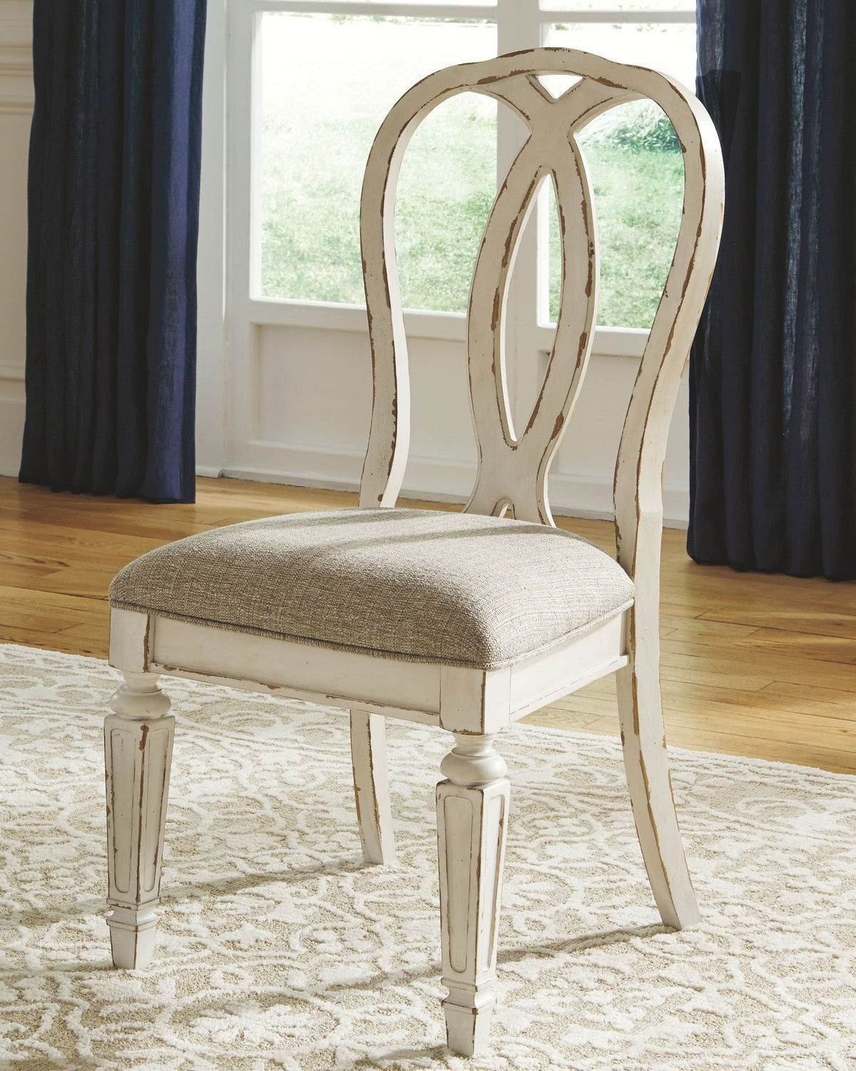 White ladderback dining chair with upholstered beige seat and turned legs