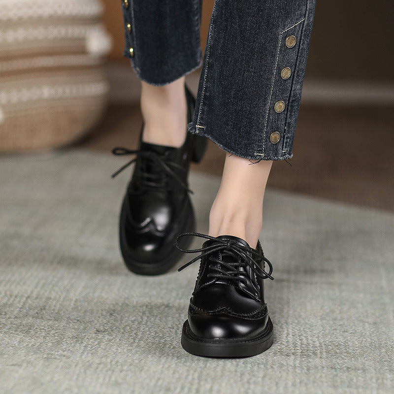 Black lace-up Oxford-style shoes with chunky block heel and round toe.