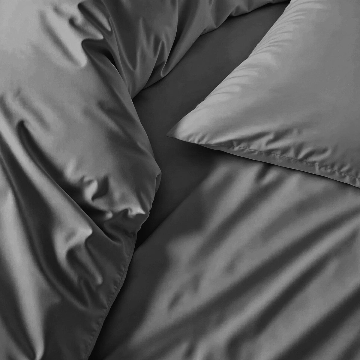 Sateen bedding set detail: smooth medium gray pillow and comforter fabric