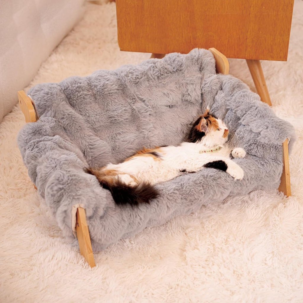 Elevated wooden cat couch bed with a fluffy gray cushion and raised sides.