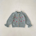 Blue-gray knitted cardigan with red floral embroidery and button front, ribbed hem.
