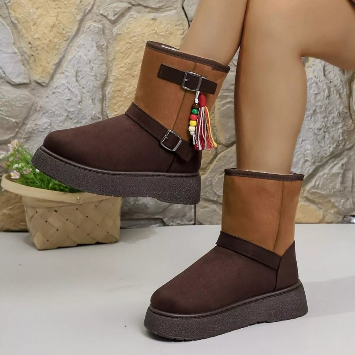 Brown ankle boots with side straps, buckles, and multicolor tassel decor.