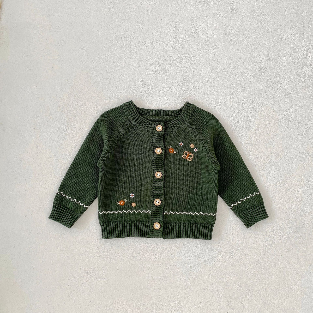 Infant dark green knit cardigan with contrast trim and button front, embroidered icons on chest