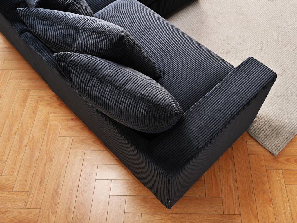 Dark blue ribbed sectional sofa chaise with multiple rolled back cushions