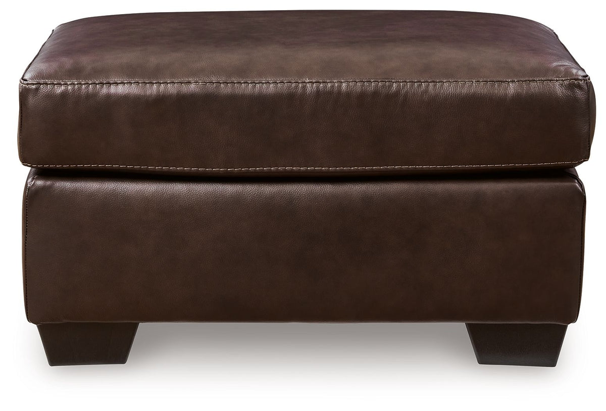 Dark brown padded ottoman with stitched top seam and dark square tapered legs