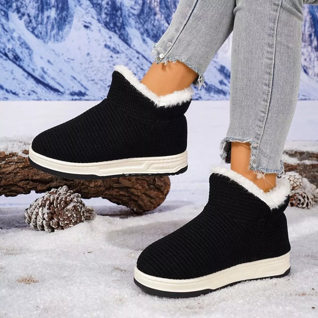Black knit ankle boots with plush white lining and cushioned sole