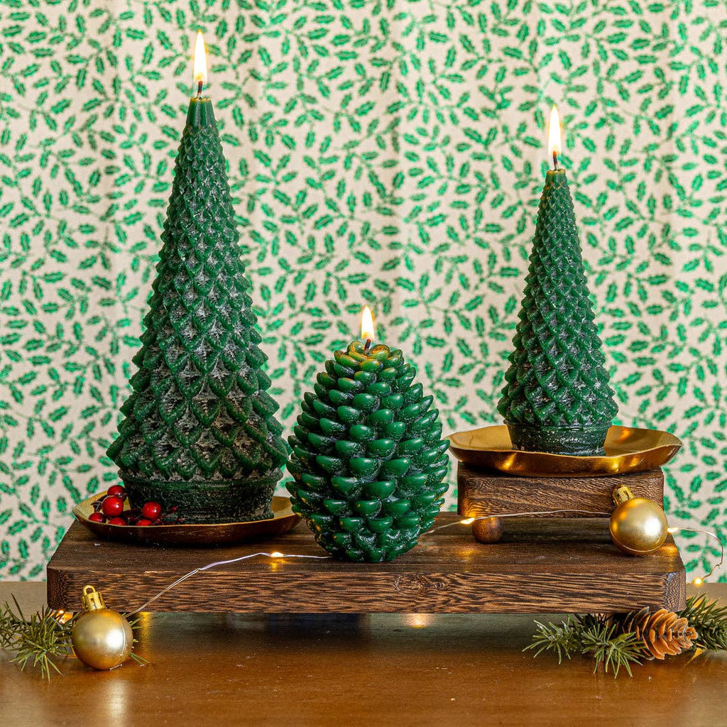 Set of tree-shaped candles with flames on a round tray
