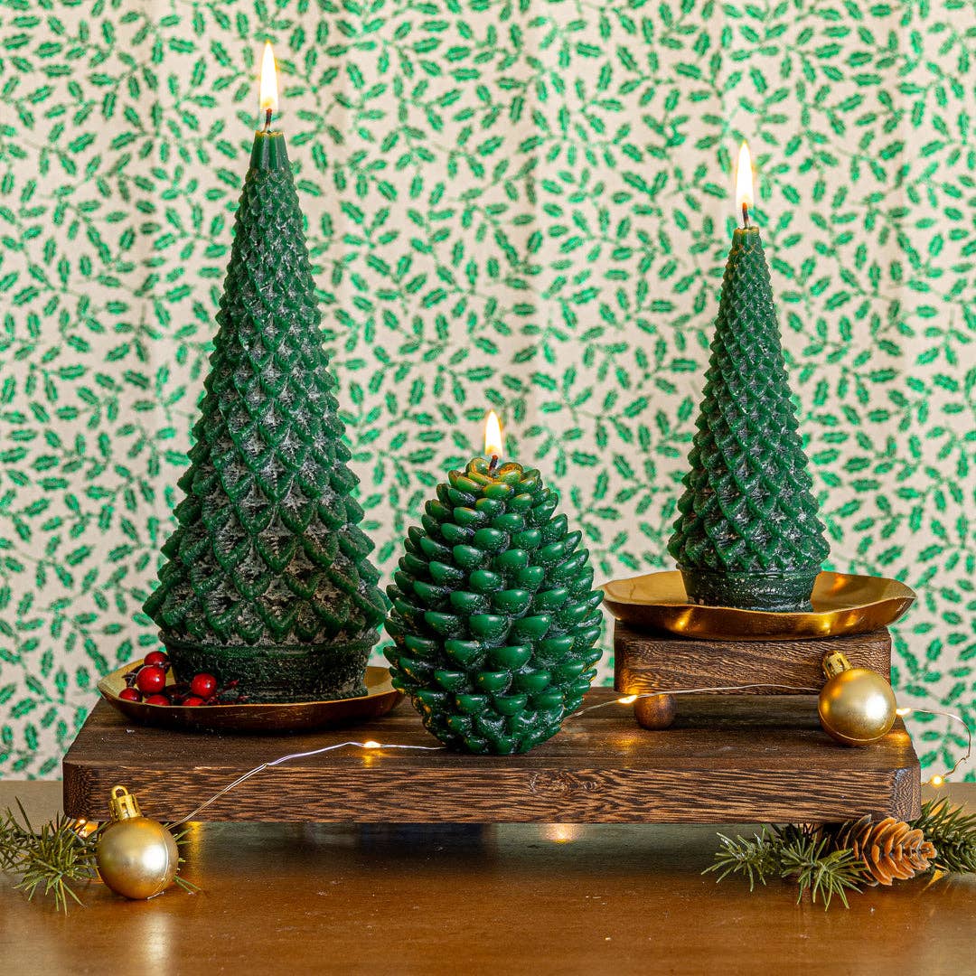 Set of tree-shaped candles with flames on a round tray